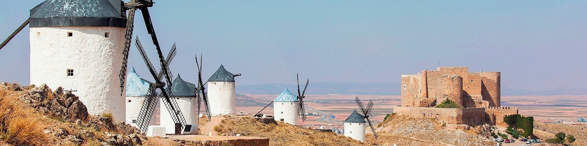 The giants of La Mancha, as Don Quixote might have seen them. Twelve windmills remain, perched atop a ridge overlooking the town of Consuegra. It's an easy day trip from either Madrid or Toledo, or stay the night and catch the windmills all lit up at night.
The windmills were built in the 16th century and used right up until the 1980s to grind grain into flour. The ones still standing are in pretty good shape, and you can venture inside for a lesson in how they operate. Hint: The tops of the windmills can be rotated to make good use of the prevailing wind. One of the windmills, named Sancho, is even cranked up and placed back into service each year as part of the Saffron Rose Festival.