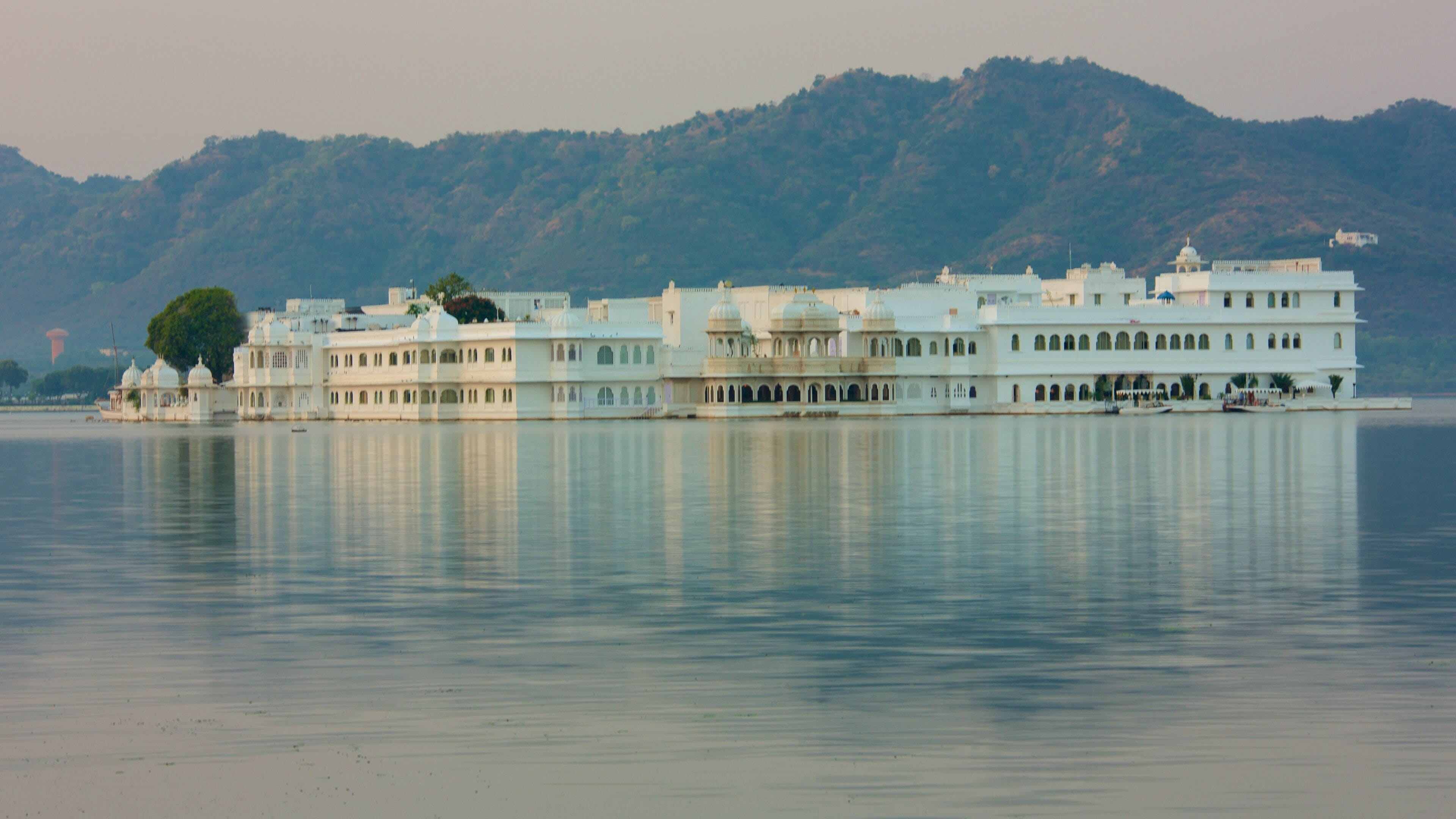 Lake Palace which includes island views, a lake or waterhole and a sunset
