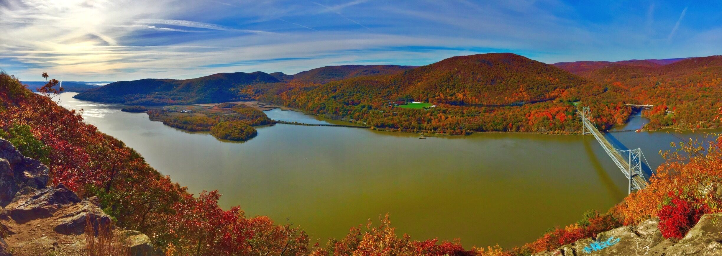 A river winding through a mountainous landscape with autumn foliage.
