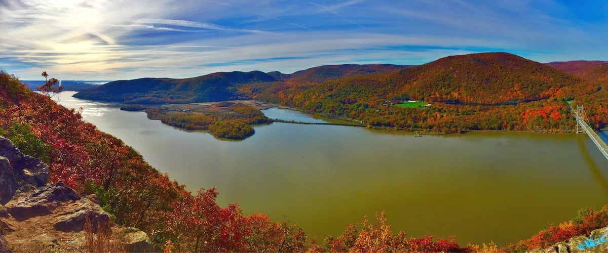 A river winding through a mountainous landscape with autumn foliage.