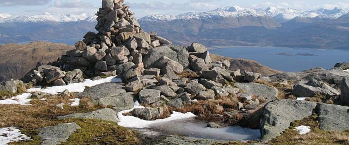 Cairn, Beinn na Cille Pile of granite stones and boulders on what may be the summit of Beinn na Cille, although there appears to be a higher boulder nearby. The snow covered hills of Appin including Argyll's highest, Bidean nam Bian in the background.