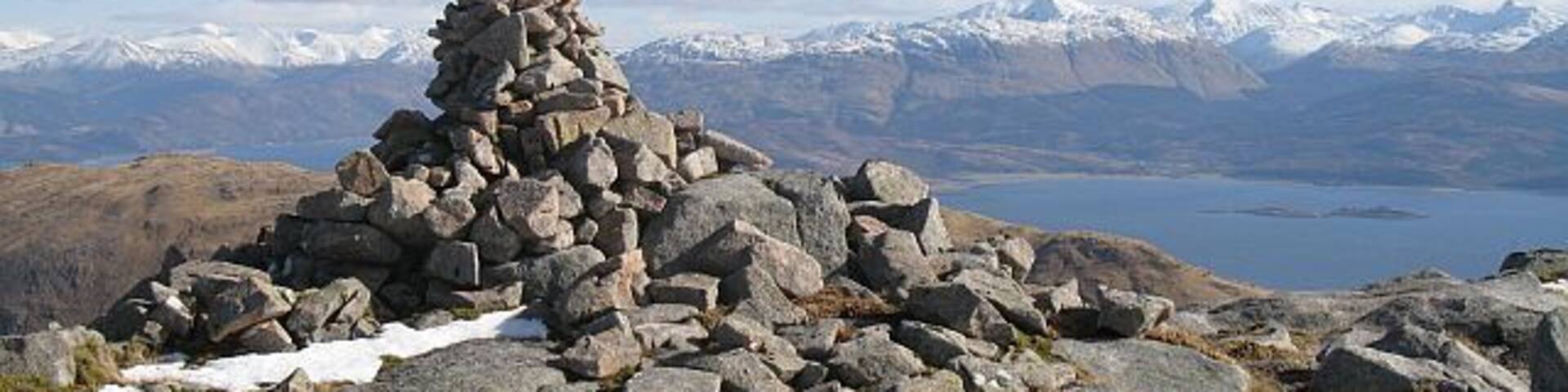 Cairn, Beinn na Cille Pile of granite stones and boulders on what may be the summit of Beinn na Cille, although there appears to be a higher boulder nearby. The snow covered hills of Appin including Argyll's highest, Bidean nam Bian in the background.