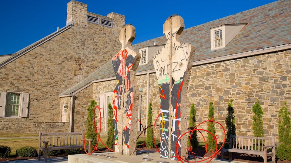 A stone building with graffiti and a wooden bench.