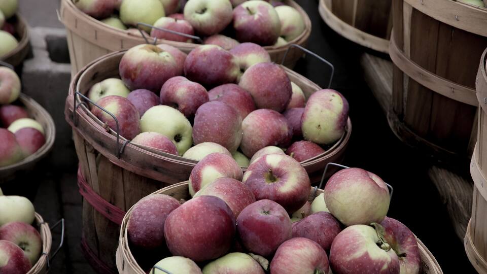 Wooden baskets filled with red and green apples.