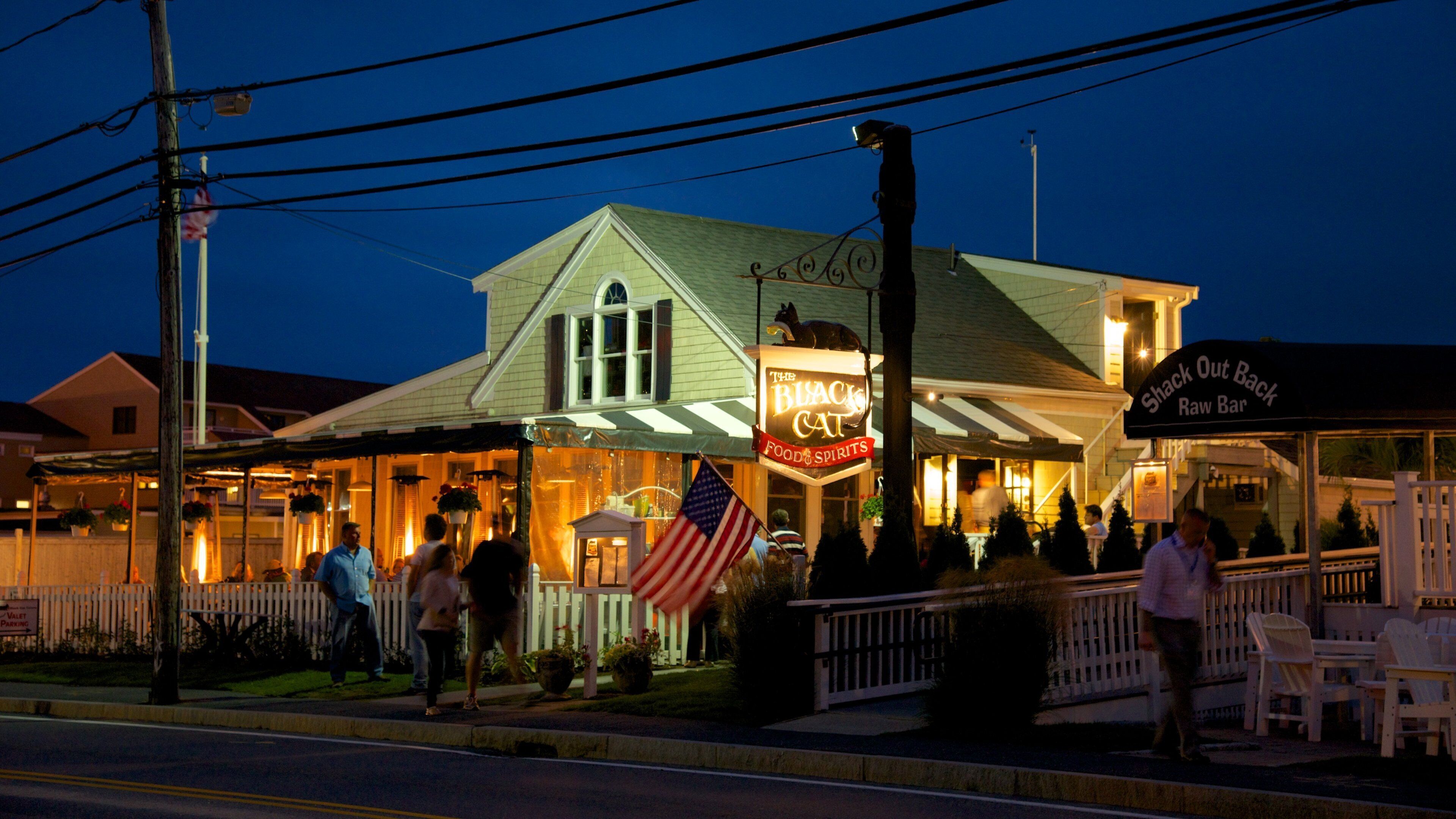 Hyannis Harbor que incluye escenas nocturnas y señalización y también un grupo pequeño de personas