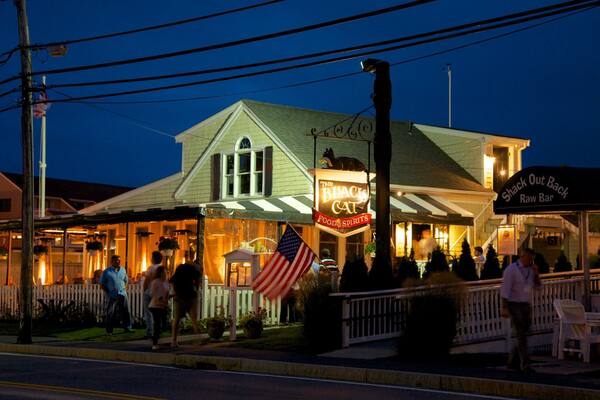 Hyannis Harbor que incluye escenas nocturnas y señalización y también un grupo pequeño de personas