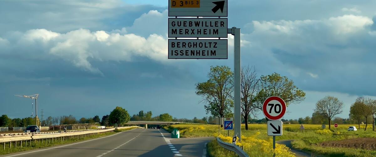 A road sign with destinations Guebwiller, Merxheim, and Bergholtz.