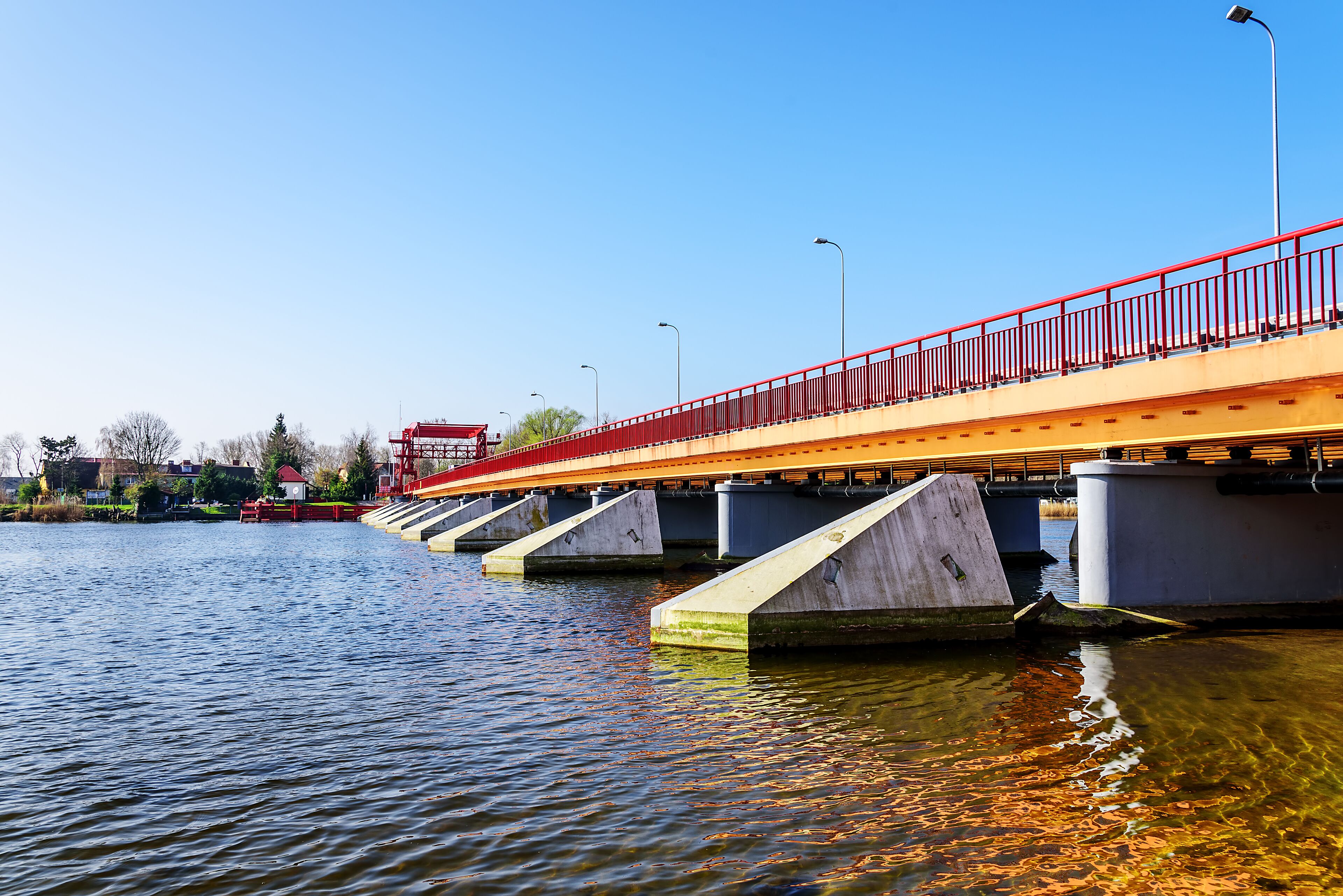 A bridge with red railings over a body of water.