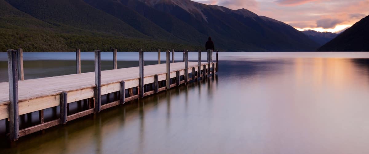 Nelson Lakes National Park which includes mountains, a sunset and a bay or harbor
