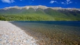 Nelson Lakes National Park showing mountains, a bay or harbor and a pebble beach