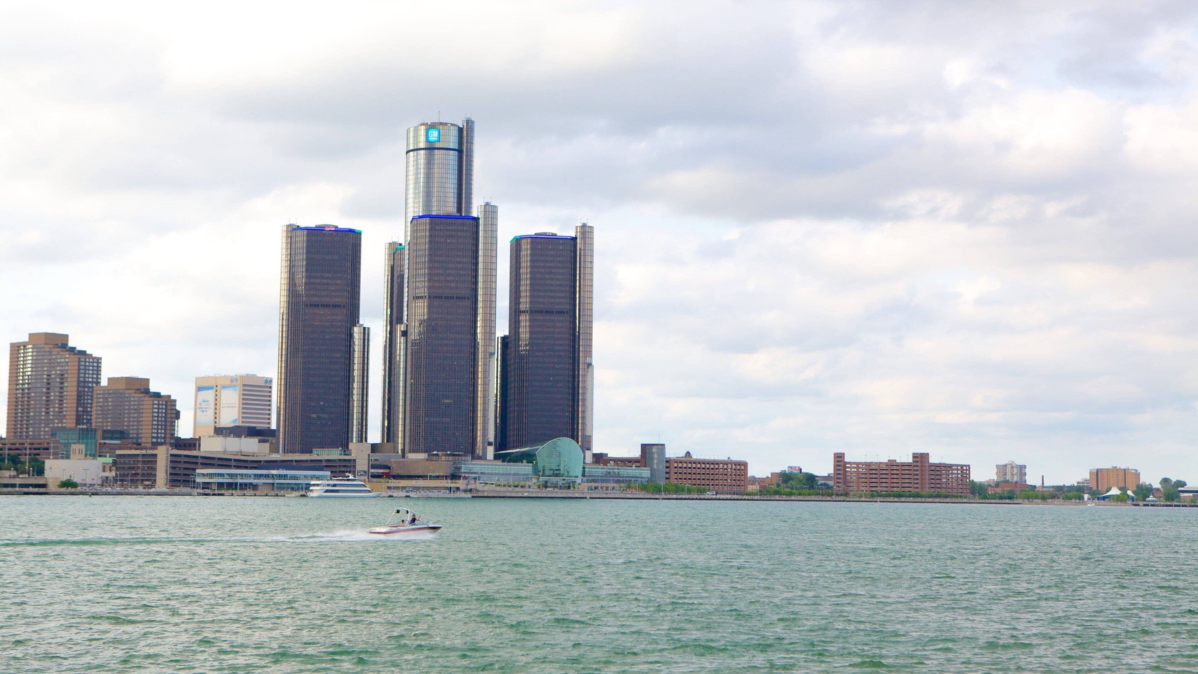 A city skyline with tall buildings and a body of water in the foreground.