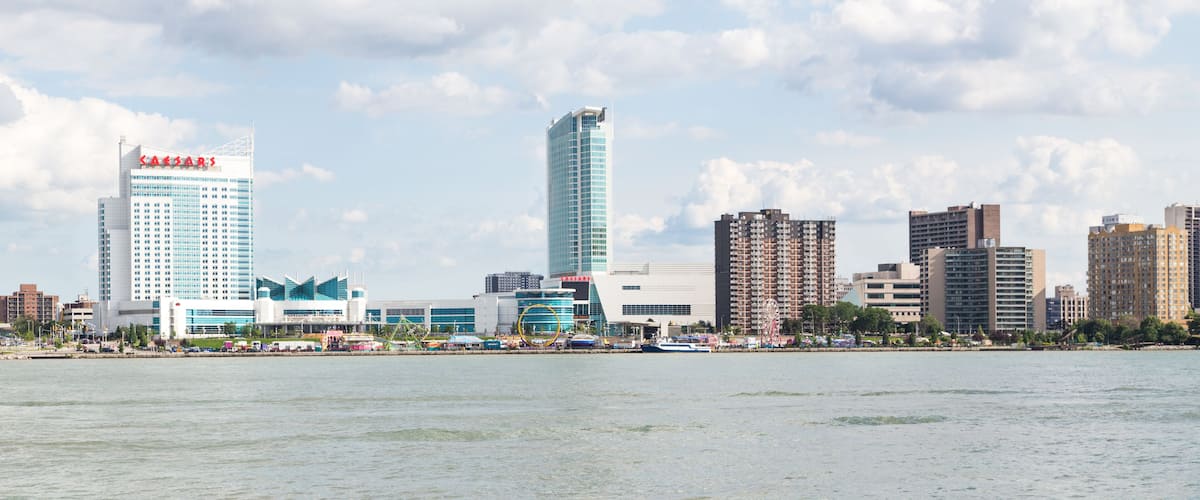 A city skyline with a prominent casino building, a tall skyscraper, and several other high-rise buildings along a waterfront.