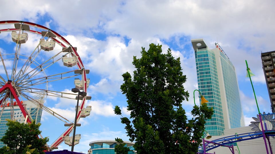 A Ferris wheel, a modern building, and a tree.