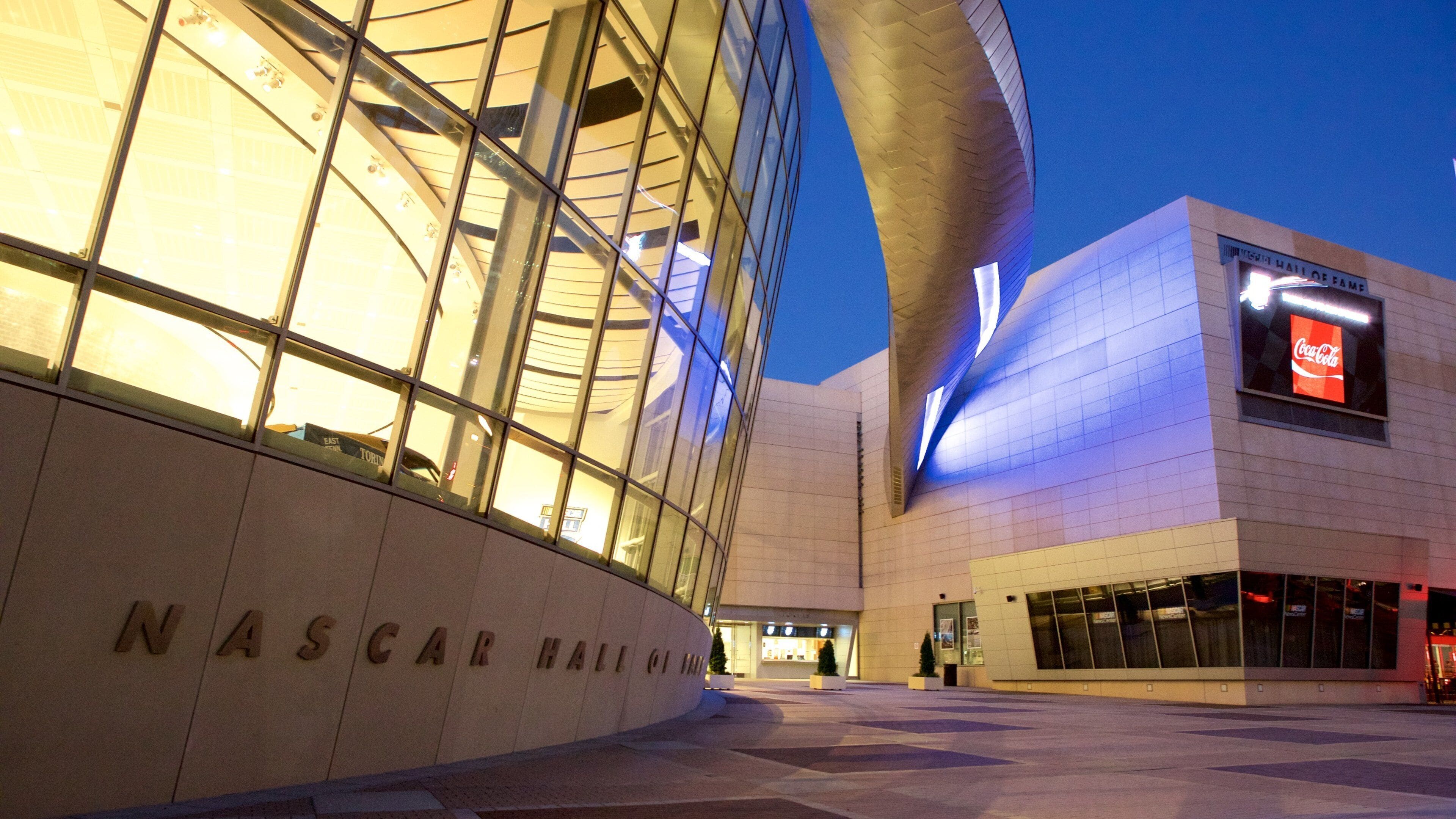 Exterior de l'edifici del Nascar Hall of Fame amb la seva façana de vidre corbat característica i el cartell de Coca-Cola.