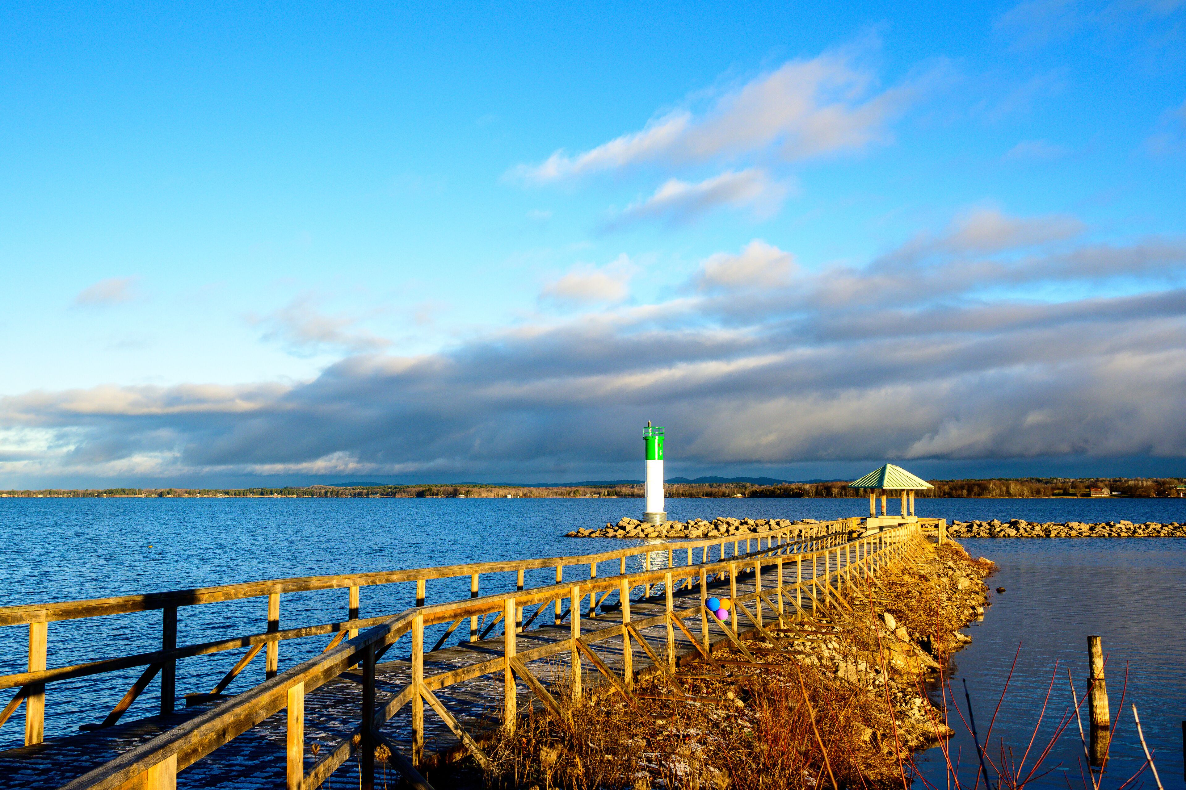 The Ottawa River in the first  light of the morning seen from the Pembroke Marina  in fall with a seawall and safe channel marker room for text	
