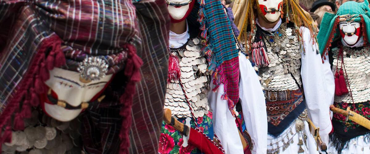 En grupp människor klädda i traditionella dräkter, med påkostade huvudbonader och andra accessoarer.