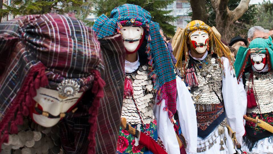A group of people in traditional costumes with elaborate headpieces and accessories.