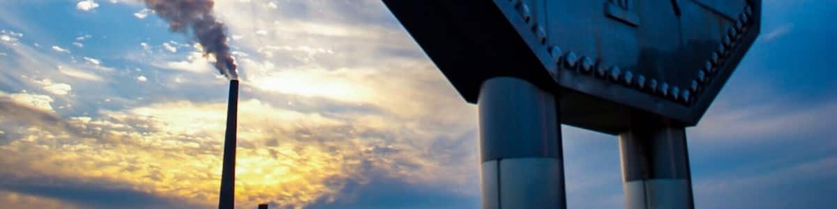 A large, metallic sign with the text "CLEAN ENERGY" against a sunset sky.