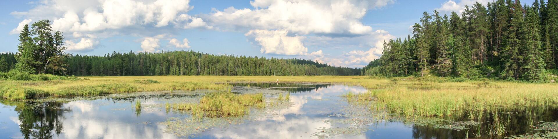 Blue mirror lake reflections of clouds and landscape. Sudbury, Ontario, Canada.