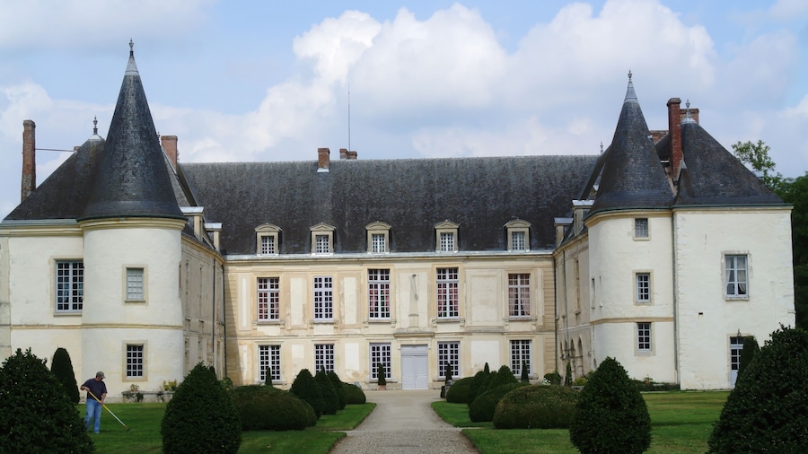 A large, historic building with a symmetrical facade, steeply pitched roofs, and a central entrance.