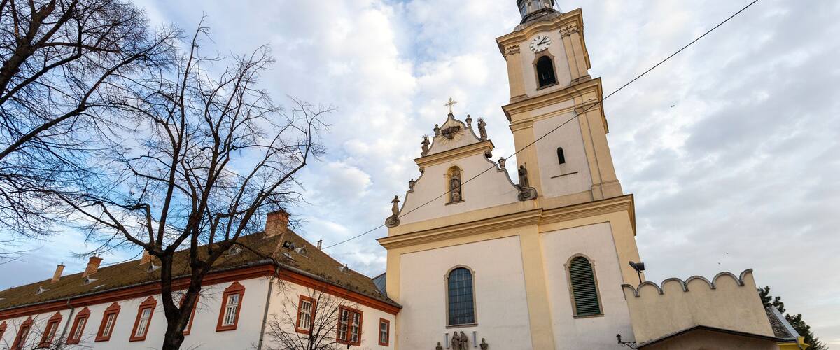 A church with a bell tower and a smaller adjacent building.
