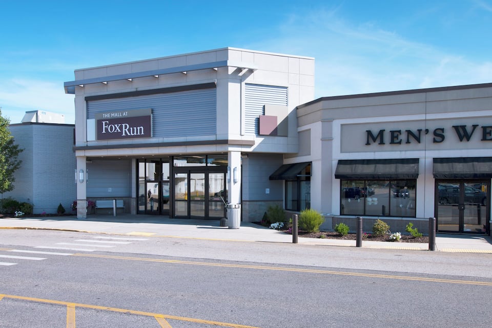 Um centro comercial com lojas, incluindo FoxRun e Vestuário Masculino.