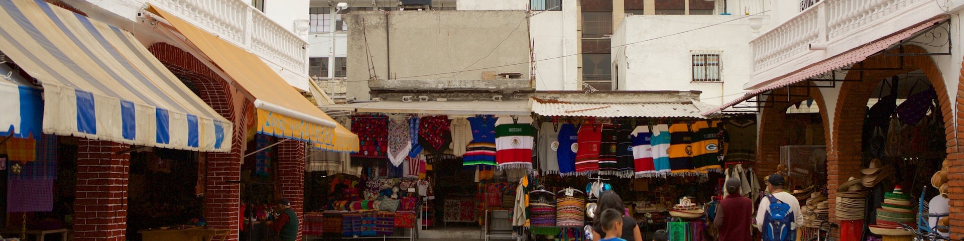 Uma rua de mercado movimentada com tecidos coloridos e chapéus tradicionais.