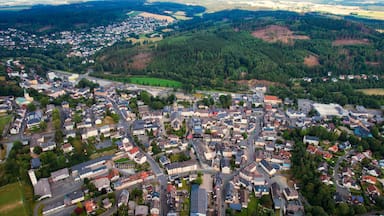 Vista aérea de uma cidade com casas residenciais, uma igreja e um grande edifício industrial.