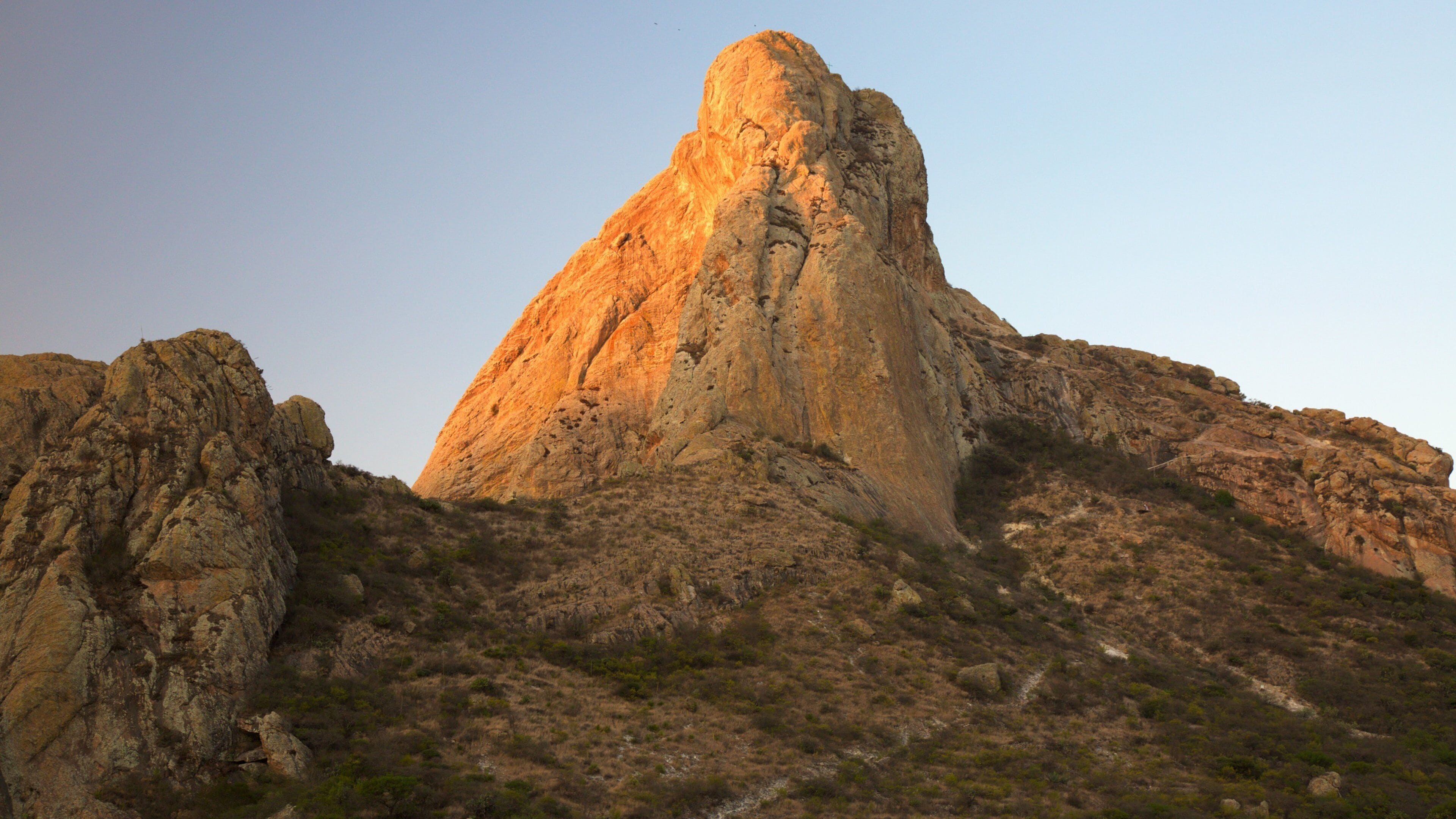 Pena de Bernal que inclui montanhas e um pôr do sol