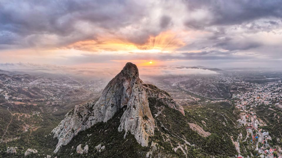 A mountain peak with a sunset in the background.