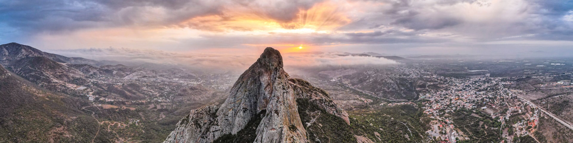 A mountain peak with a sunset in the background.