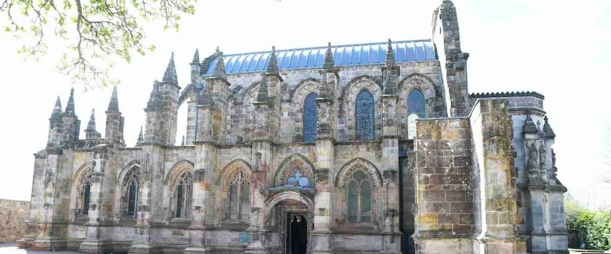 A historic cathedral with Gothic architecture, featuring pointed arches, a large rose window, and a blue-tiled roof.