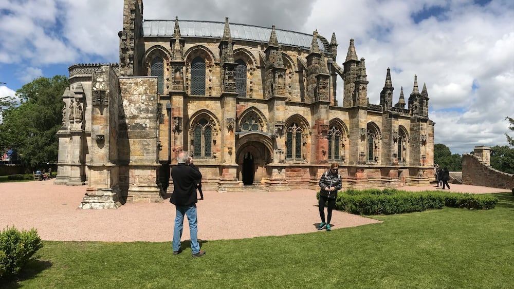 A historic stone building with intricate architecture, including pointed arches and spires.