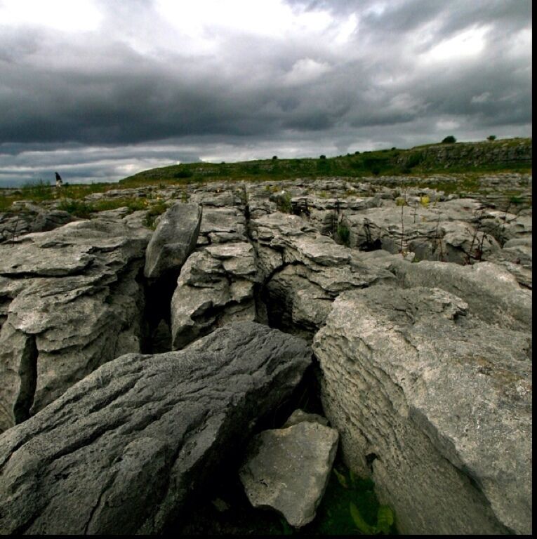 A rocky landscape with large boulders and a cloudy sky.