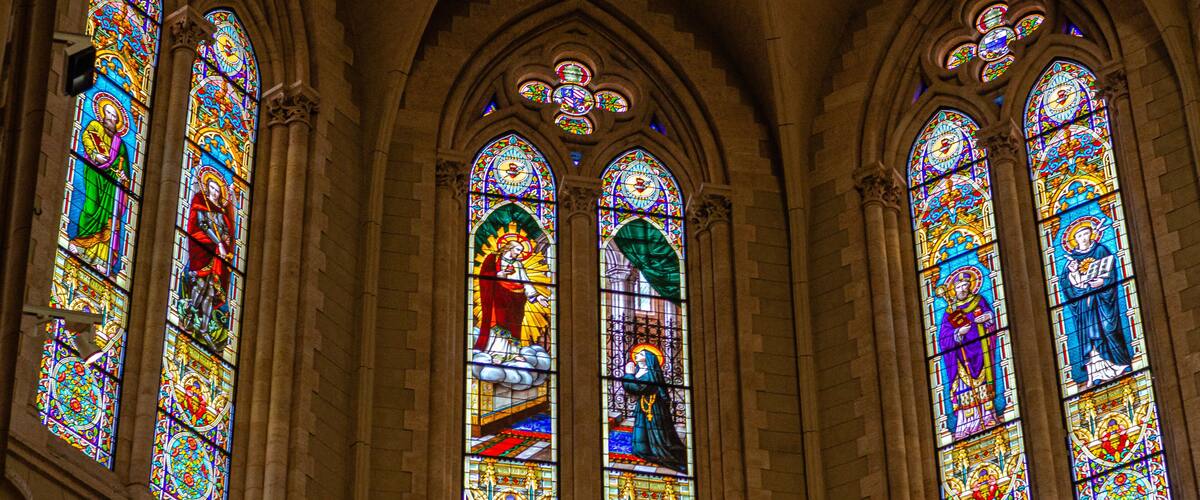 A cathedral with stained glass windows depicting religious scenes.