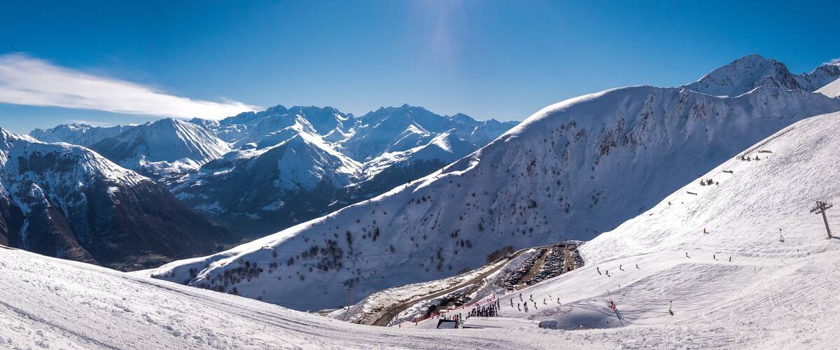 A snow-covered mountain range with ski slopes and a ski lift.