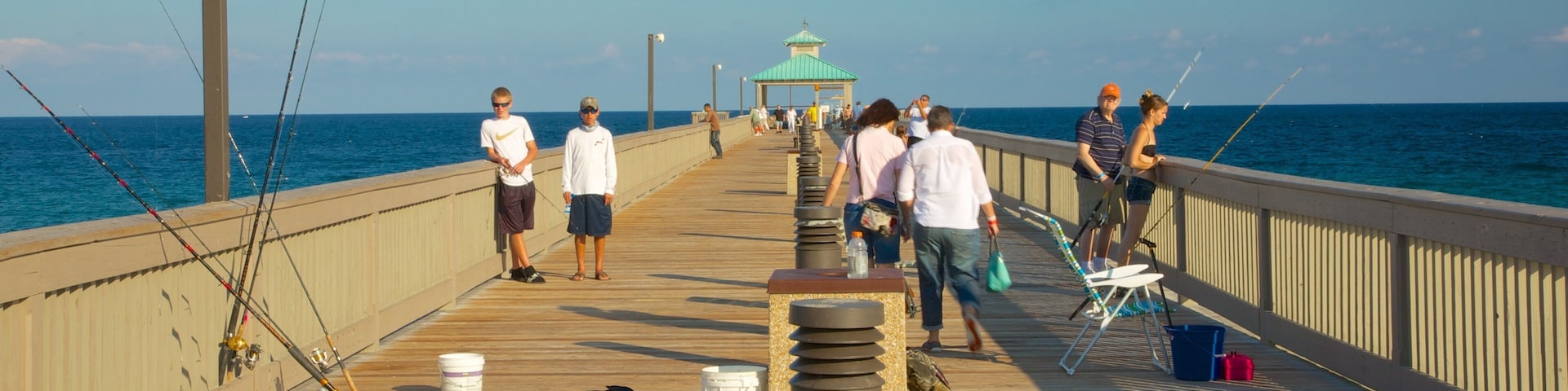 Fishing enthusiasts gather on Deerfield Beach Pier enjoying a sunny day in Florida
