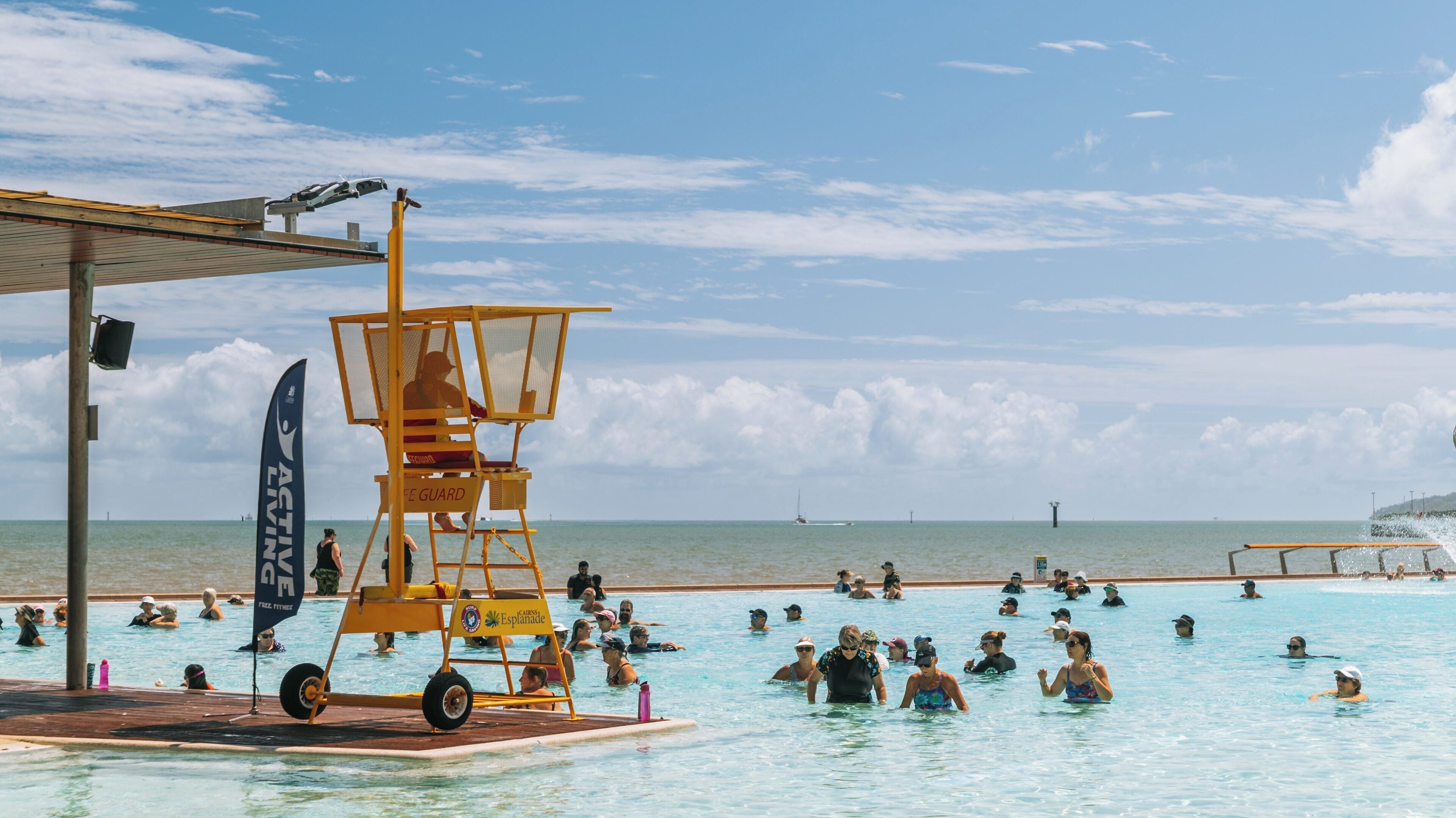 Busy day at Cairns Esplanade swimming lagoon in Cairns North, Queensland with lifeguard on duty and visitors enjoying the sun and water activities