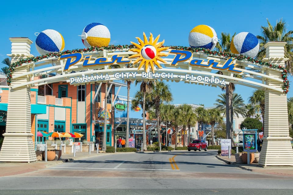 The entrance to Pier 70 in Panama City Beach, Florida, with a sun and beach ball decoration.