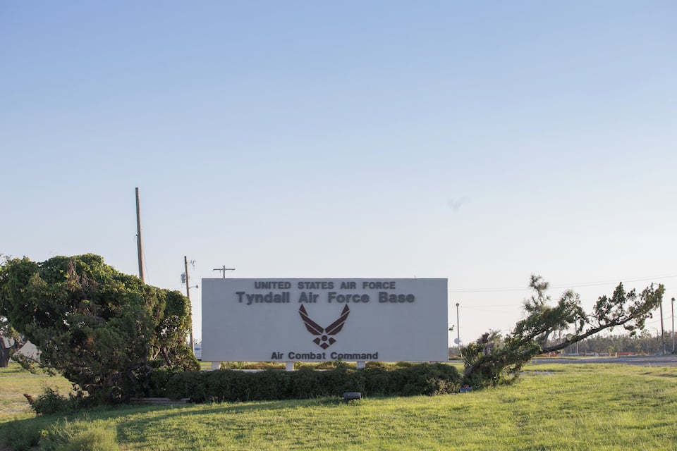 Un anuncio de la Fuerza Aérea de los Estados Unidos, Base Aérea Tyndall, con un logotipo de alas y una estrella.