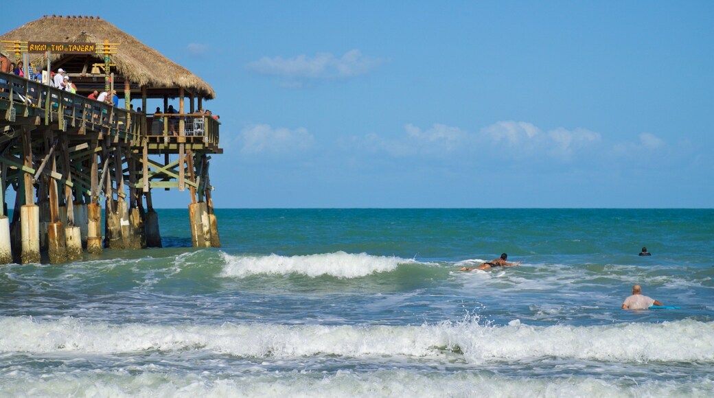Cocoa Beach Pier which includes general coastal views and swimming as well as a small group of people