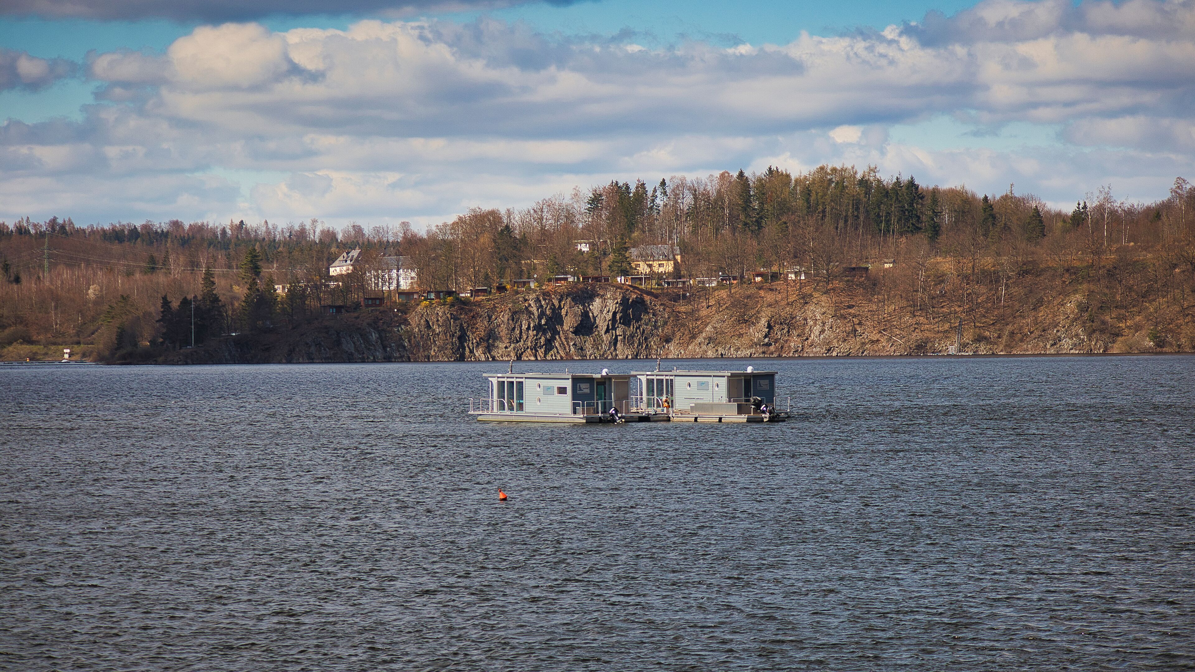 Moderne schwimmende Häuser auf der Bleilochtalsperre vor der felsigen Uferkulisse bei Saalburg-Ebersdorf, Thüringen, Deutschland