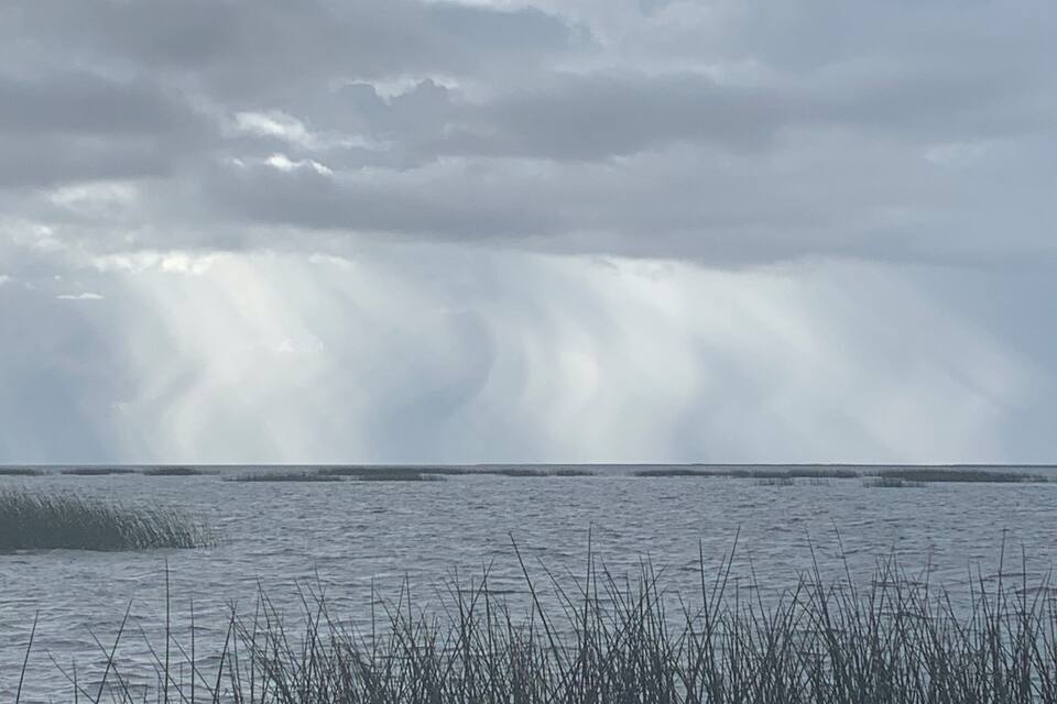 Eine Küstenlandschaft mit bewölktem Himmel und Wellen.