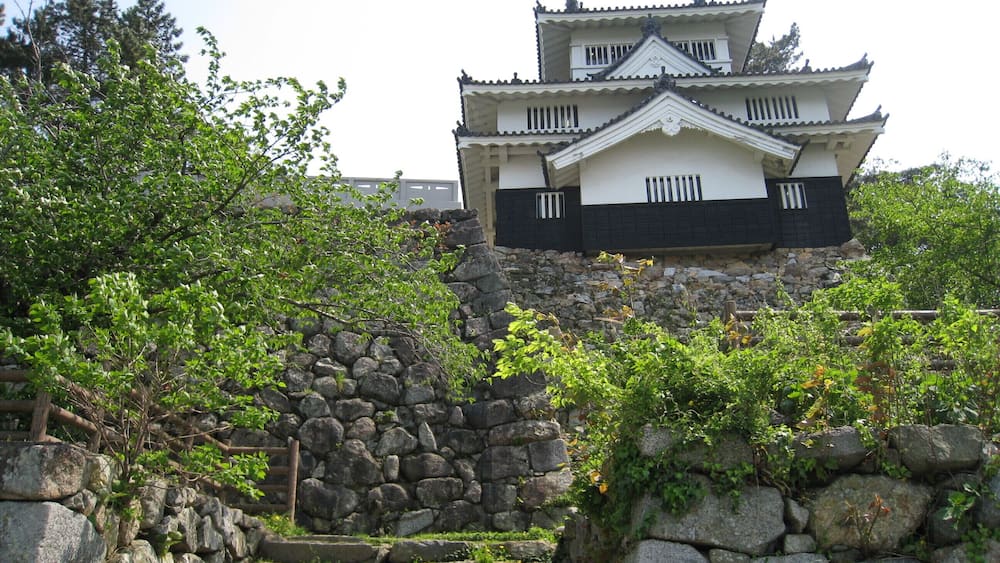 A traditional Japanese castle with a stone staircase leading up to it.