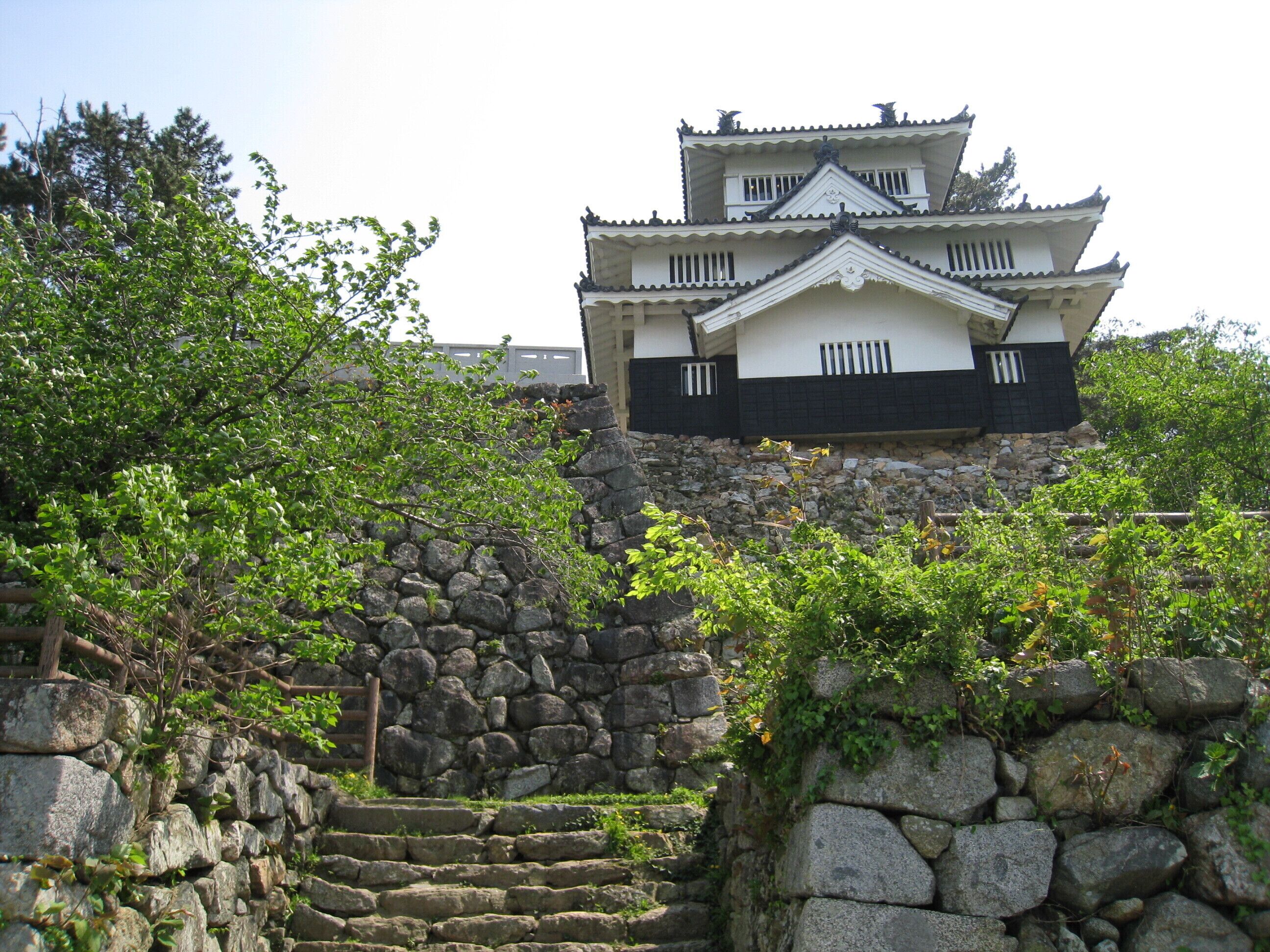 A traditional Japanese castle with a stone staircase leading up to it.