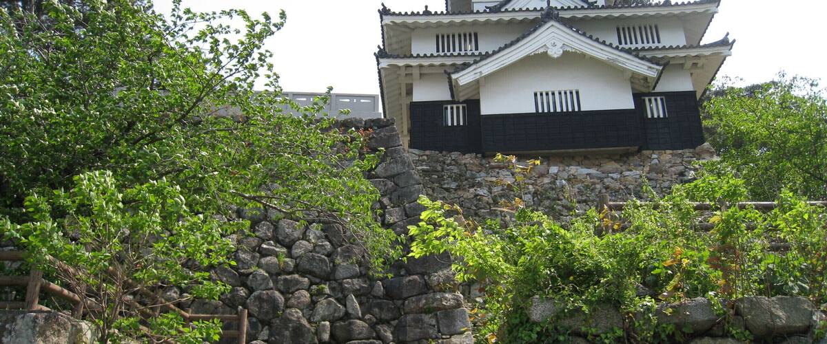 A traditional Japanese castle with a stone staircase leading up to it.