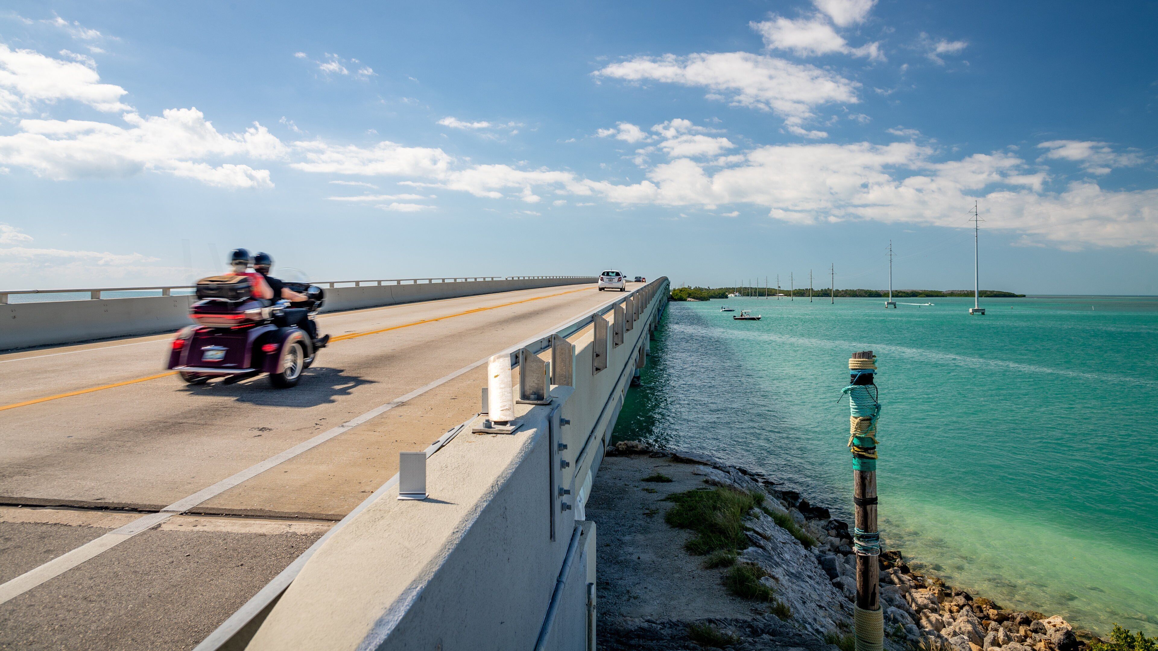 Seven Mile Bridge which includes general coastal views, a bridge and motorbike riding