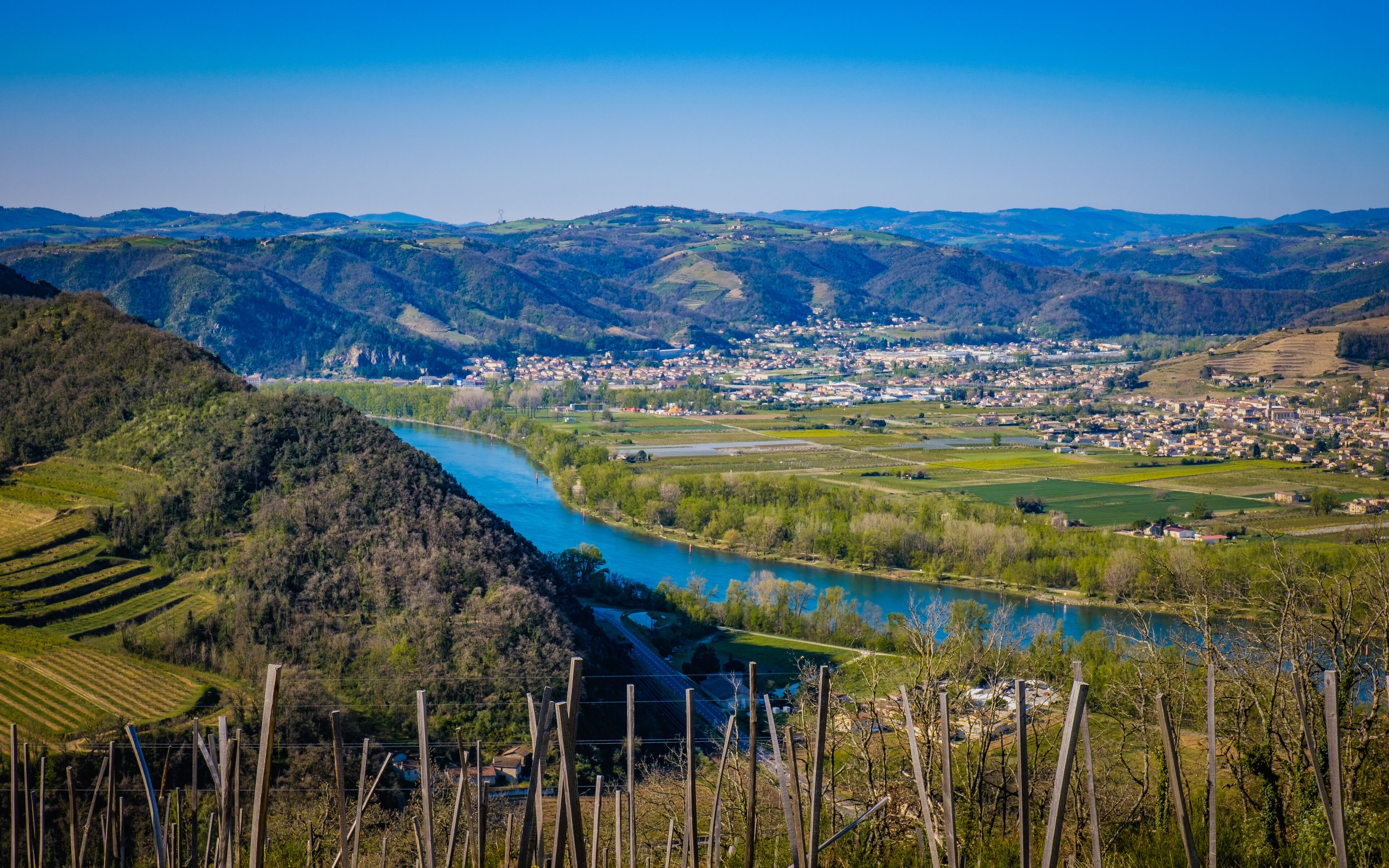 A river winding through a valley with a town in the distance.