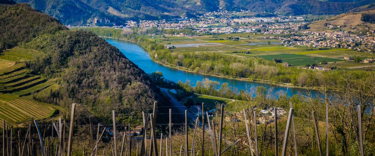 A river winding through a valley with a town in the distance.