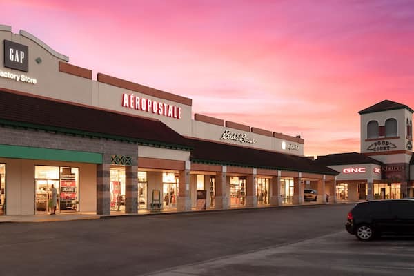 St. Augustine Premium Outlets which includes signage, shopping and a sunset